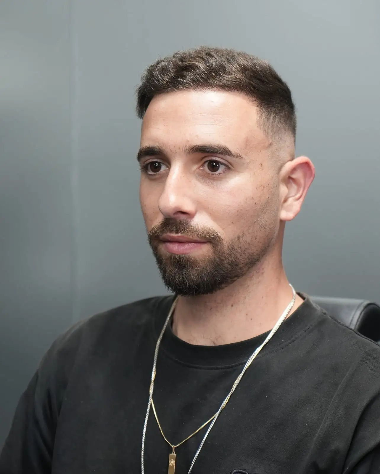 Mid fade with a short textured crop and a shaped beard at ONYX barbershop in Hallandale Beach, FL