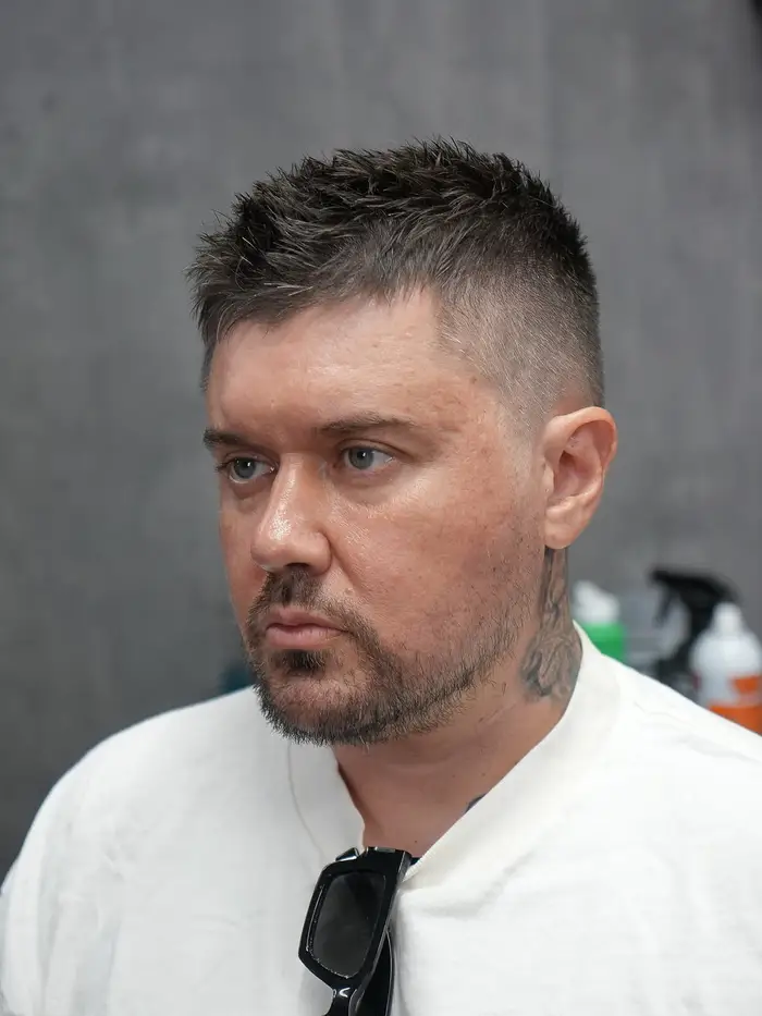 Skin fade with a short spiky crop on salt-and-pepper hair at ONYX barbershop in Hallandale Beach, FL