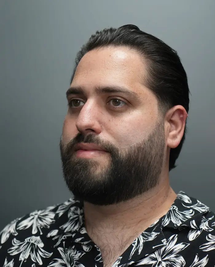 Slicked-back taper on thick coarse hair with a full beard at ONYX barbershop in Hallandale Beach, FL