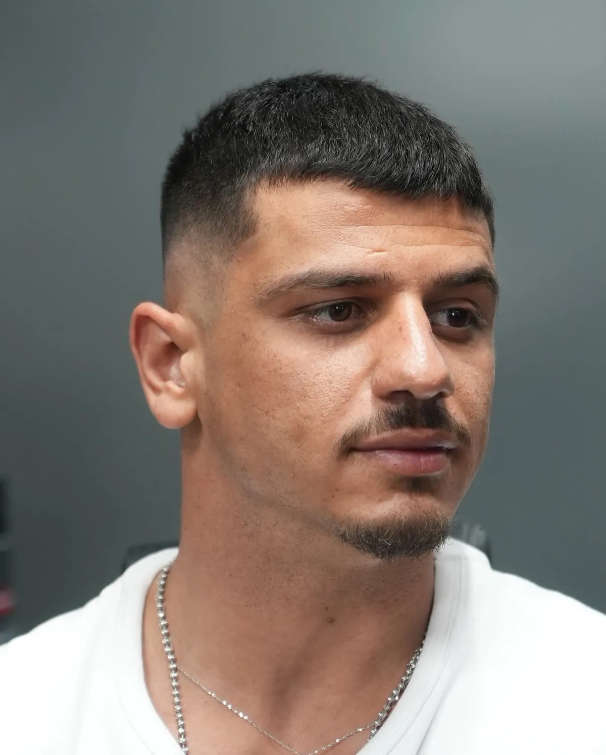 Soft crop haircut with a high fade and weight kept at the front at ONYX Barbershop in Hallandale Beach, FL