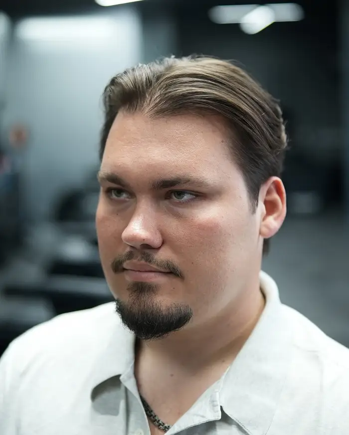Longer slicked-back cut with a taper at the sides at ONYX barbershop in Hallandale Beach, FL